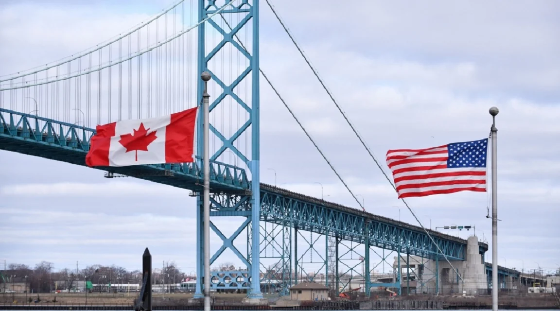 Drapeaux du Canada et des États-Unis près d'un pont frontalier